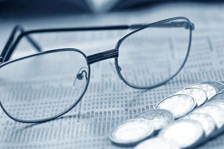 glasses and coins on the tableの写真素材