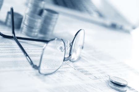 glasses and coins on the tableの写真素材