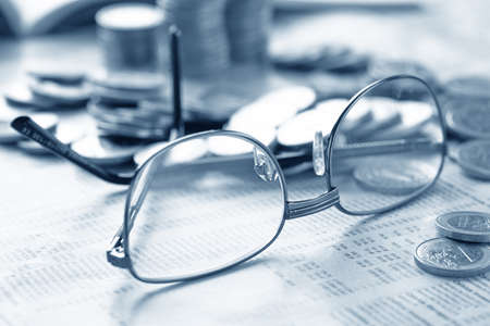 glasses and coins on the tableの写真素材
