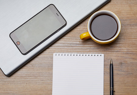 phone, coffee and notebook on the office tableの写真素材
