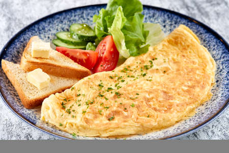 omelet with fresh vegetables and toastsの写真素材