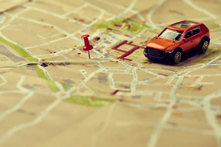 travel concept - small toy car on the mapの写真素材
