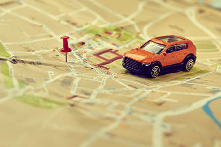 travel concept - small toy car on the mapの写真素材