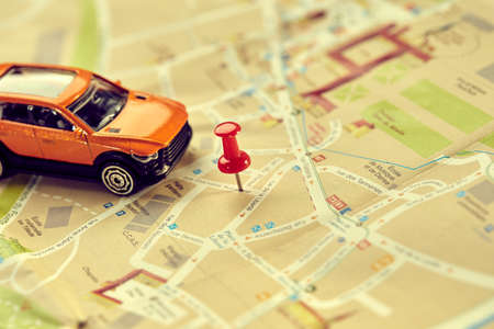 travel concept - small toy car on the mapの写真素材