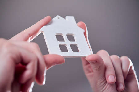 Hand holding white icon houseの写真素材