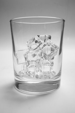glass with ice cubes on whiteの写真素材