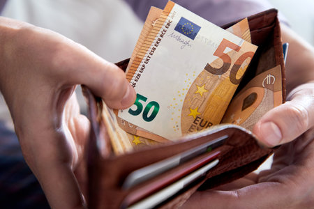 man hand putting money closeupの写真素材