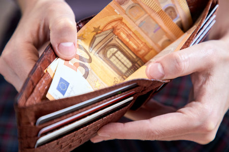 man hand putting money closeupの写真素材