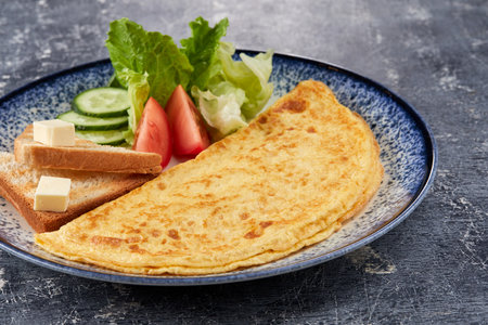 omelet with toasts and vegetablesの写真素材