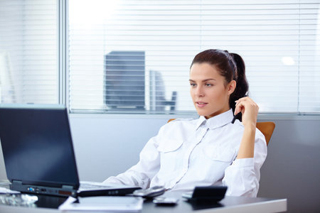 Young businesswoman sitting at workplaceの写真素材