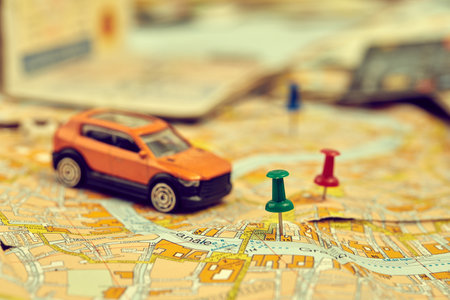 travel concept - small toy car on the mapの写真素材