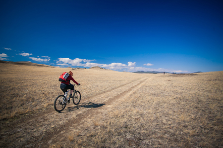 Young girl riding a bicycle in the mountains.の写真素材