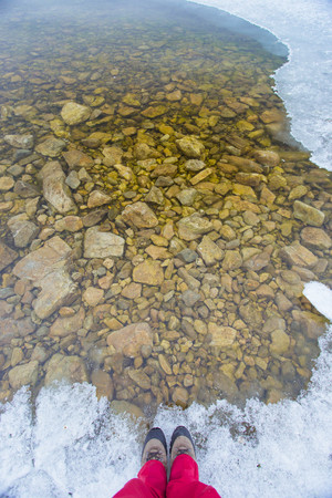 First person on the boundary of ice and water in Baikal lakeの写真素材