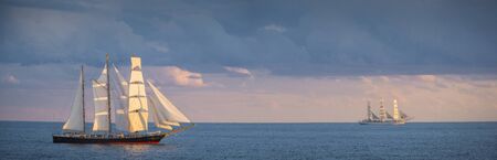 Panorama of sailboats in the sea at sunset