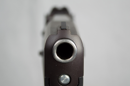 Closeup shot looking down the barrel and front sight of a pistol