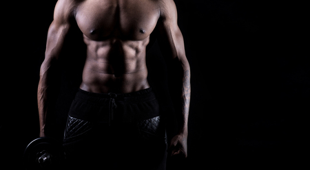 African male model showing muscles in studio with a black backgroundの写真素材