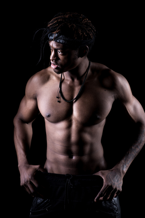 Studio shot of muscular afro-american man posing with black backgroundの写真素材