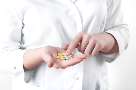 A woman is holding a lot of different pills in handsの写真素材