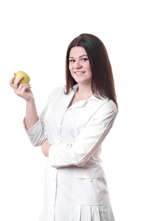 Smiling female doctor holding a green apple isolated on a white backgroundの写真素材
