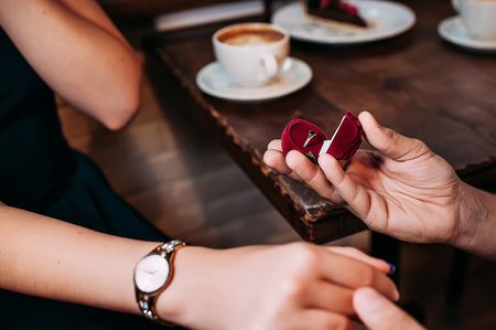 Man proposing his woman by a cup of coffeeの写真素材