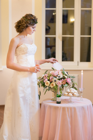 Nice bride near the table with a huge bouquetの写真素材