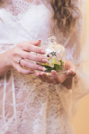 Bride wedding morning. A gentle flower under the glass in a girl's handsの写真素材