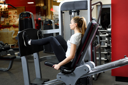Girl training hard alone in a gym. Exercise for leg strengthの写真素材