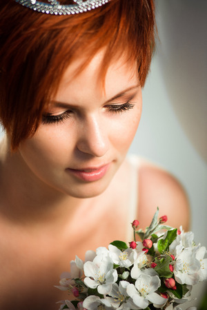 Close-up portrait. A close look on a girl looking at the bouquet in her handsの写真素材