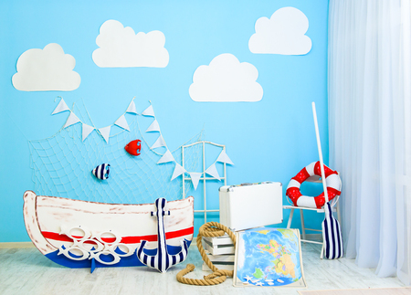 Boyish marine cute room decorated as a sea ship with a boat and fish in a web. Interior room for a boyの写真素材