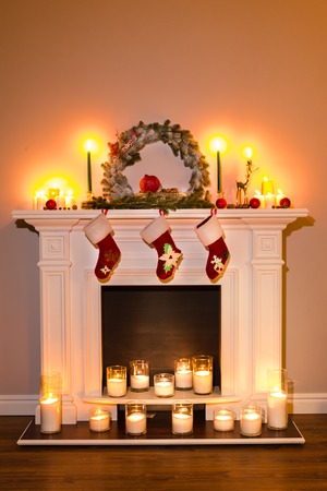 Traditional fireplace with lots of candles and christmas attributes. Room Christmas Tree Fireplace Lightsの写真素材