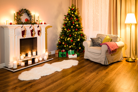 Cozy living room full of warm light from decorations for a coming Christmas, nice fireplace, soft sofa and a great tree. Room Christmas Tree Fireplace Light, Xmas Home Interior Decorationの写真素材