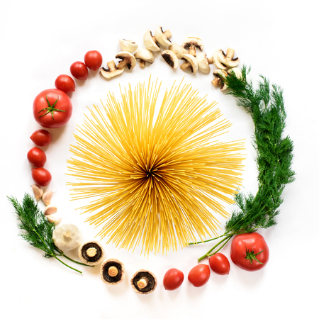 Flat lay. Fettuccine and spaghetti with ingredients for cooking pasta on a white background, top view. A minimalistic a composition of fresh vegetables circle and a salute of pastaの写真素材