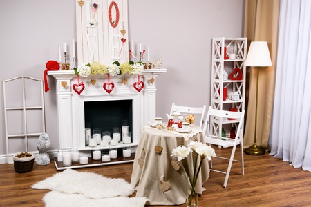 Interior decorated for of St. Valentine's Day. A comfortable lighted room decorated for St. Valentines Day, heart-shaped figures in redの写真素材