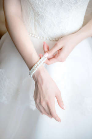 Bride wedding details. Bride straightening a pearl braceletの写真素材