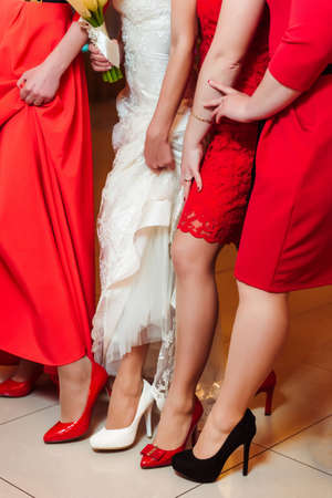 Company of girls in red dresses with a bride. Weddingの写真素材