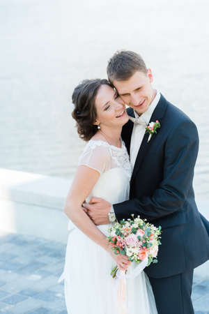Happy young couple just married. Laughing young wedding couple hugging each other happilyの写真素材