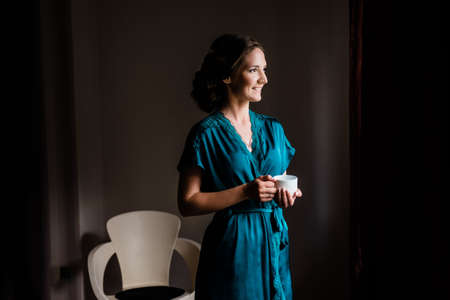 Portrait of pretty young woman holding a coffee cupの写真素材