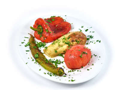 Vegetable stew on a white plate. Pepper, tomato, eggplant. Isolated on white backgroundの写真素材