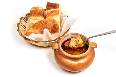 Clay pot of shchi soup with meat served with a slice of bread. Serving dishes in a cafe, restaurant, for a menu. Isolated on white backgroundの写真素材