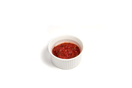 Tomato sauce in round ceramic plate isolated of white background for food menu and other designsの写真素材