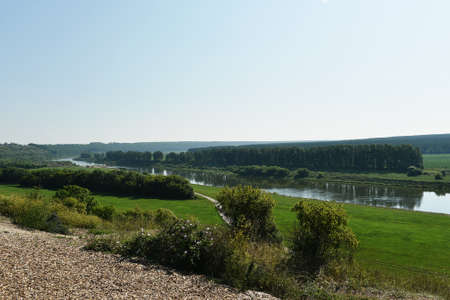 Beautiful landscape of a large Russian river and wide fields summer landscape with a great perspective. Wide river with green coasts and sky with clouds. The photo was taken from a great heightの写真素材