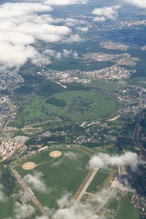 High angle flight view of the airport territory with light clouds. View of the ground from airplane windowの写真素材