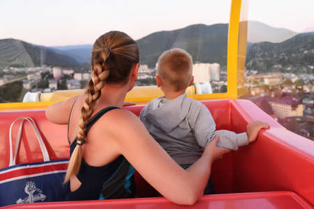 Mother and son enjoying aerial cityscape view from the Ferris wheel.の写真素材