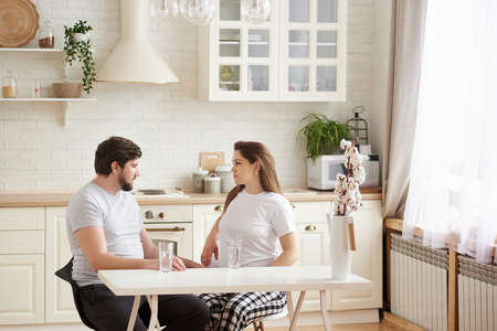 Portrait white Caucasian couple two people, a pregnant woman with husband in the kitchen, lifestyle healthy pregnancy happy life concept. Wellbeing at home and family pregnancy concept, motherhoodの写真素材