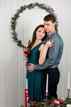 A warm picture of a family couple hugging happily, Christmas atmosphere in a lighted room.の写真素材