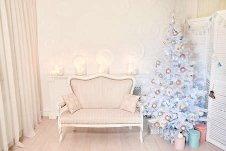 Stylish Christmas interior decorated in white colors. New Year interior room with presents and New year tree. Comfort home.の写真素材