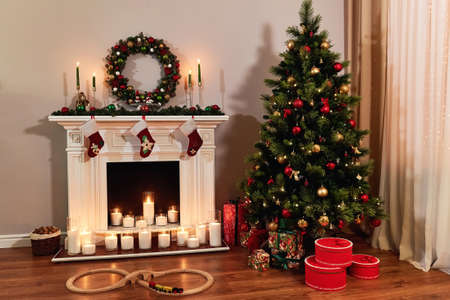Living room home interior with decorated fireplace and christmas tree. Christmas warm cozy interior room, in anticipation of the holiday. New year design.の写真素材