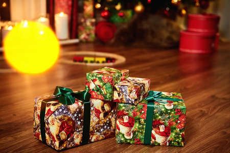 Christmas gift box under a tree with defocused lights and copy space.の写真素材
