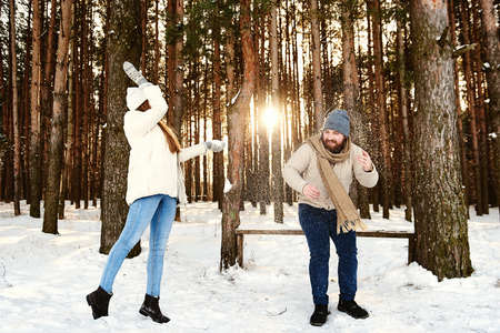 Xmas Morning. Funny Couple Throwing Snow Walking In Snowy Winter Forest Enjoying And Having Fun Outside. Free Space. People having fun during winter holidays. Lifestyle capture, Weekends out of townの写真素材