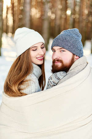 Xmas Morning.Close-up portrait of smiling couple girl looking at bearded guy with love, men looking at camera, couple enjoying an outdoors walk on snowy winter holiday, Christmas vacation togetherの写真素材